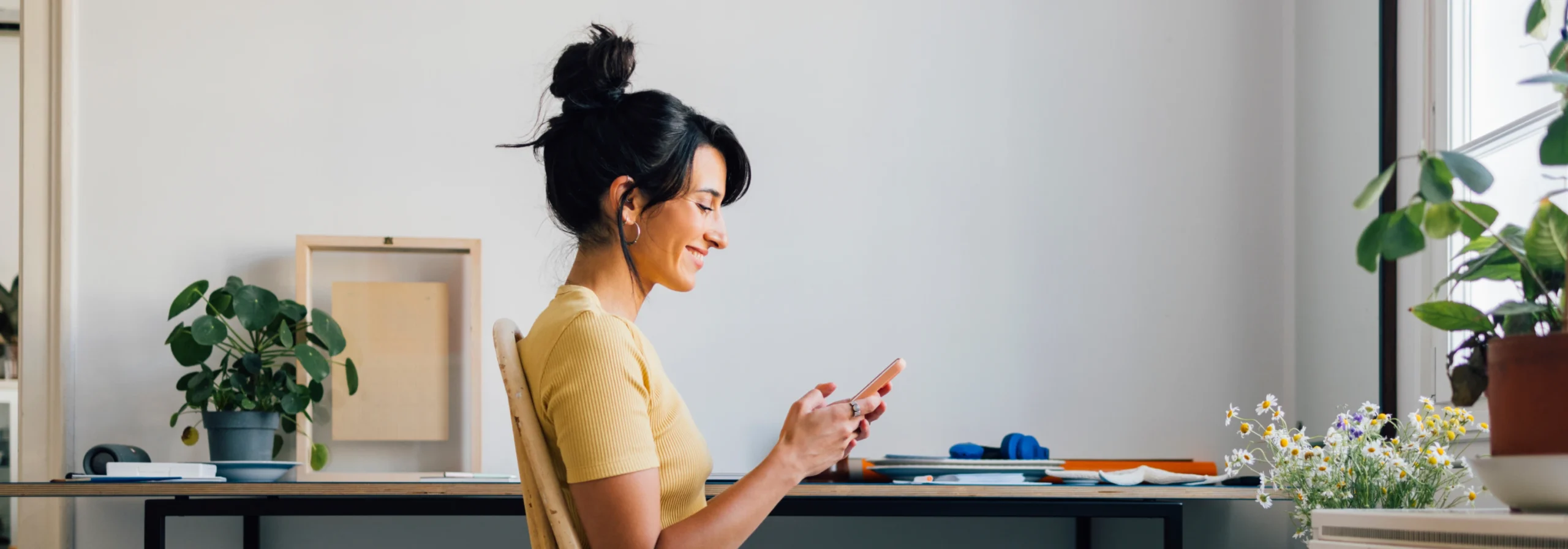 Woman using phone in home office.