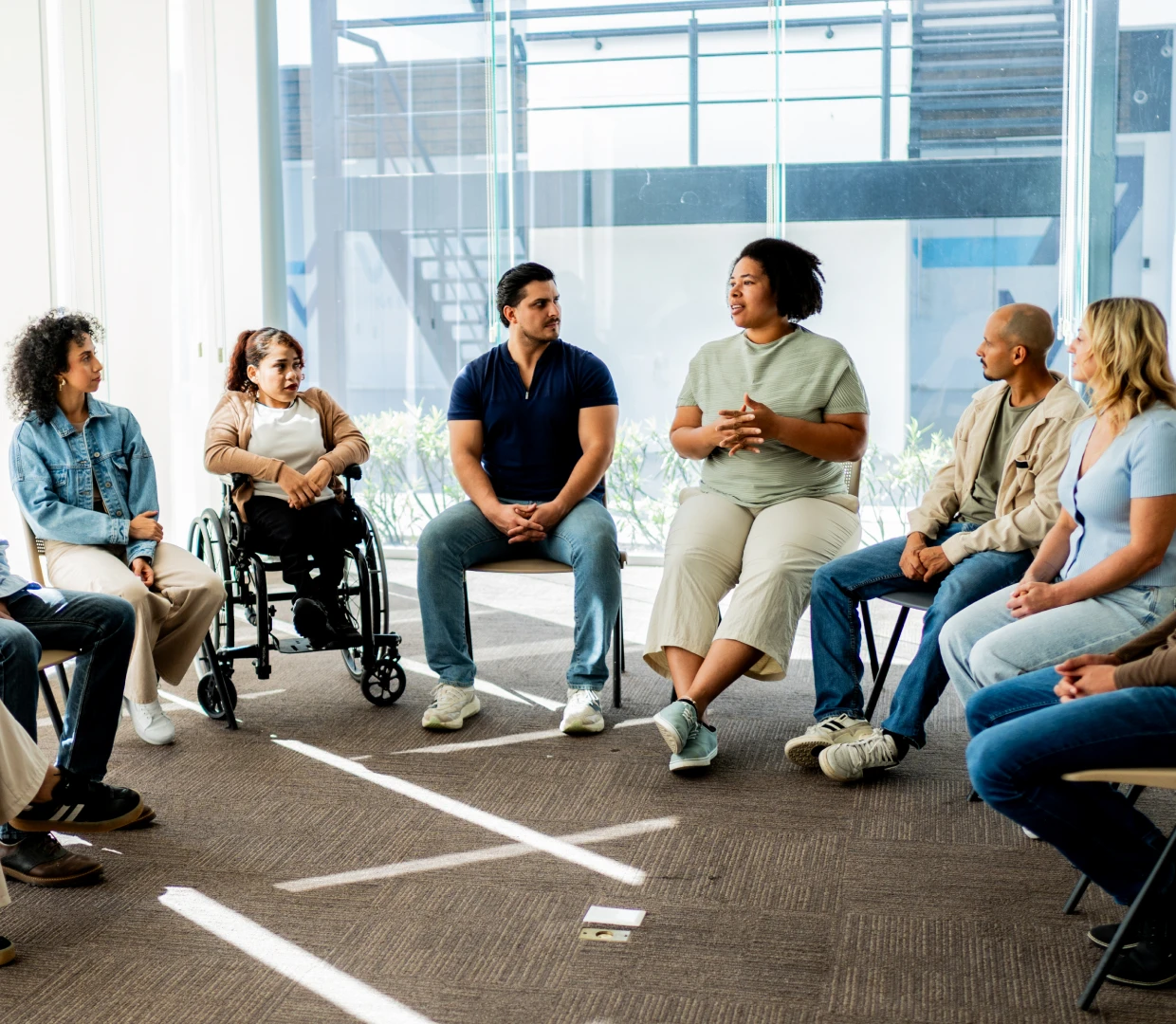Group discussion with diverse participants in circle.